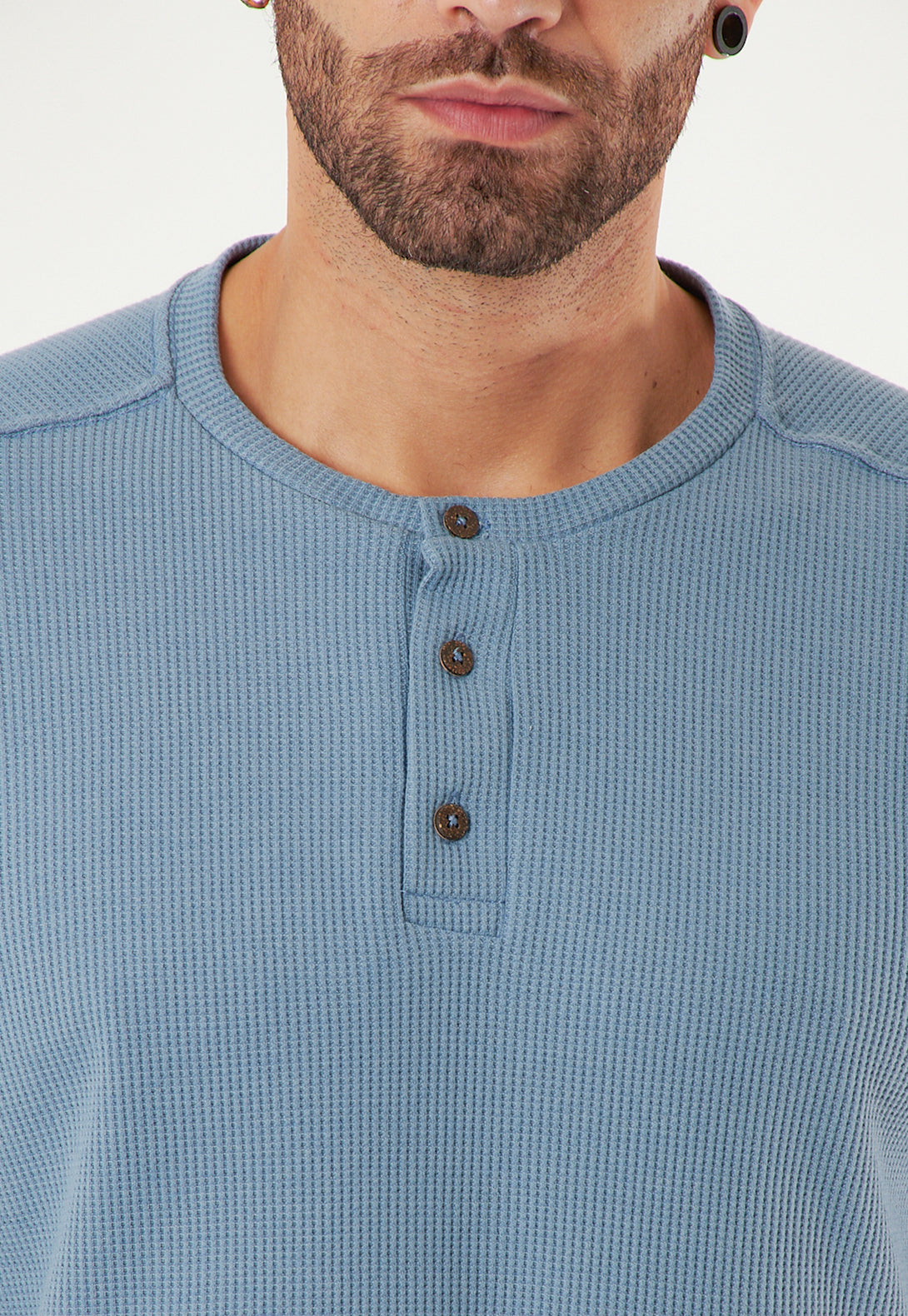 Camiseta con botones frontales para mayor funcionalidad.