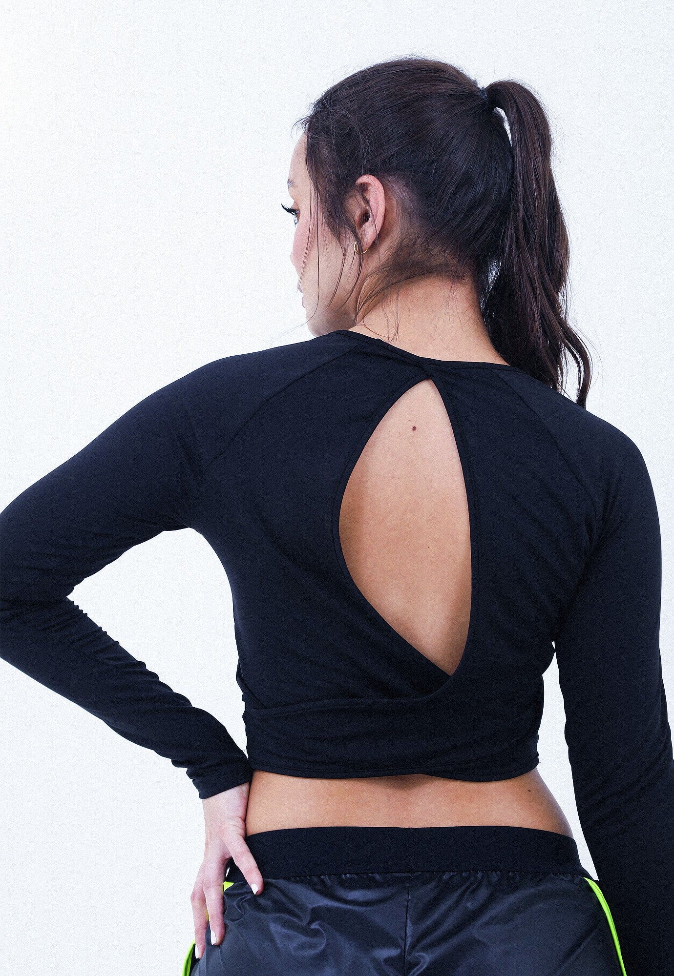 Camiseta deportiva negra manga larga, escote redondo sesgado, espalda cruzada y trasnfer reflectivo en centro frente para mujer