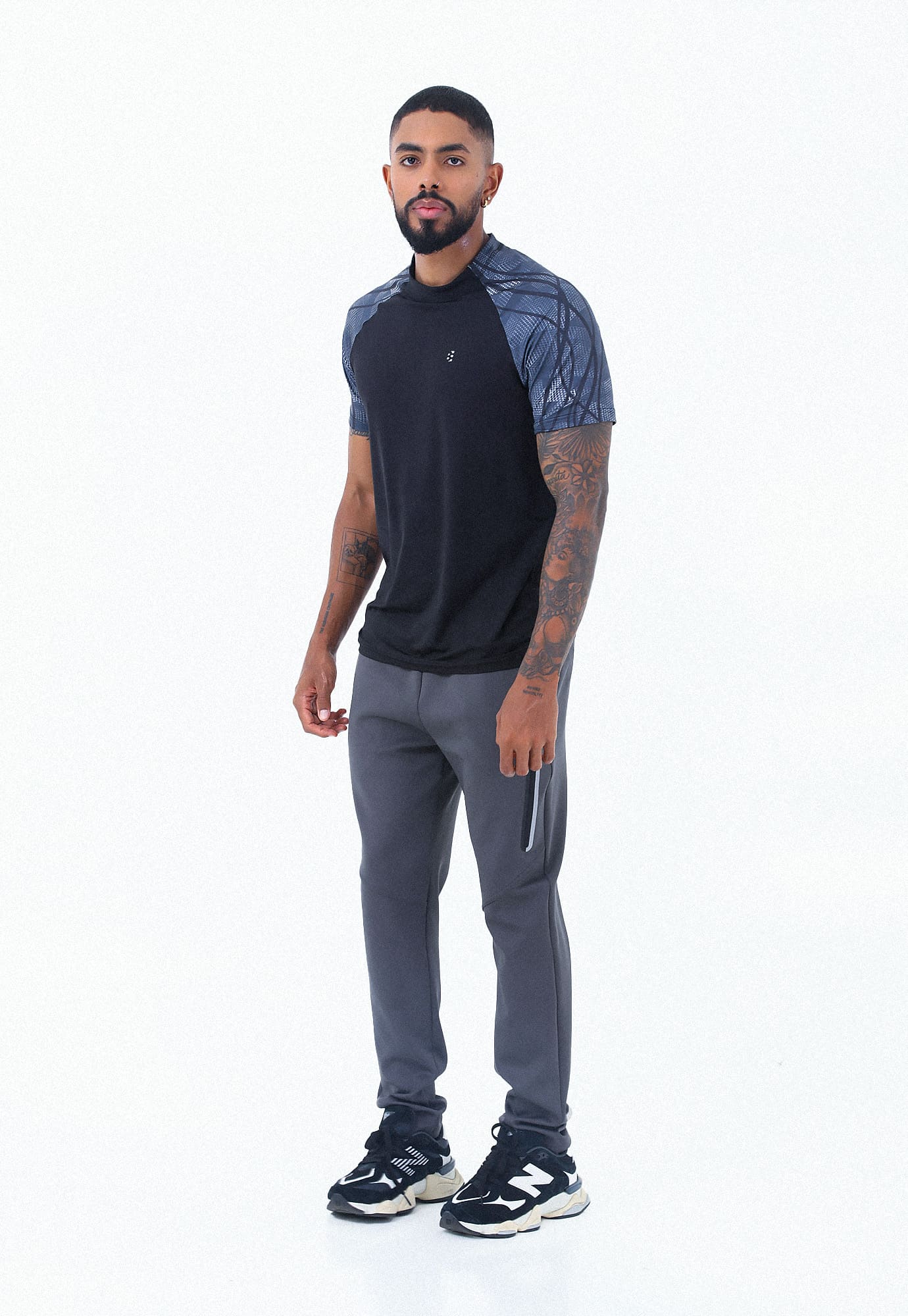 Camiseta deportiva negra con mangas cortas tipo ranglán sublimadas y detalle reflectivo para hombre