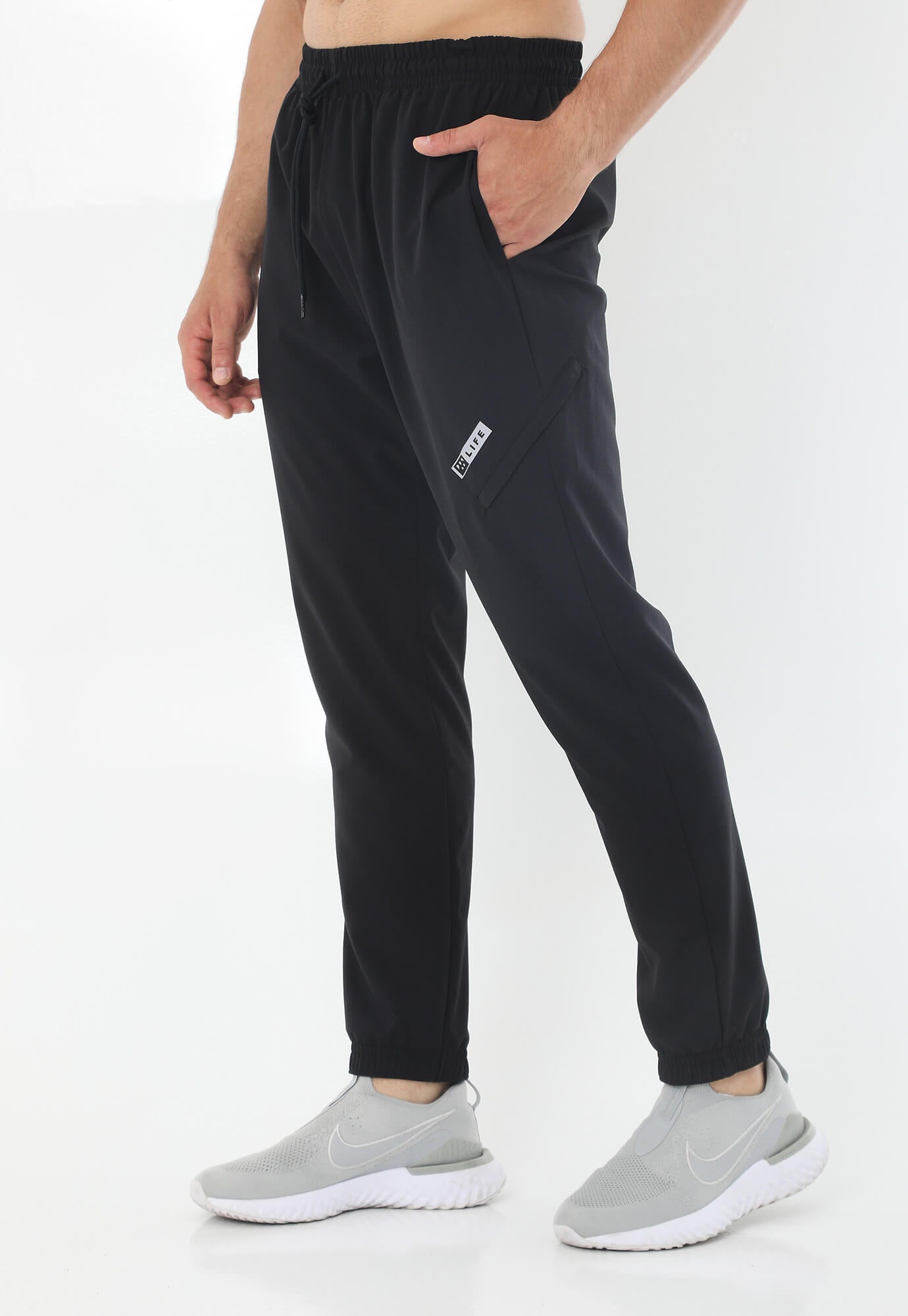 Pantalón deportivo negro tipo jogger con silueta ajustada, pretina con cordón ajustable y bolsillos laterales para hombre
