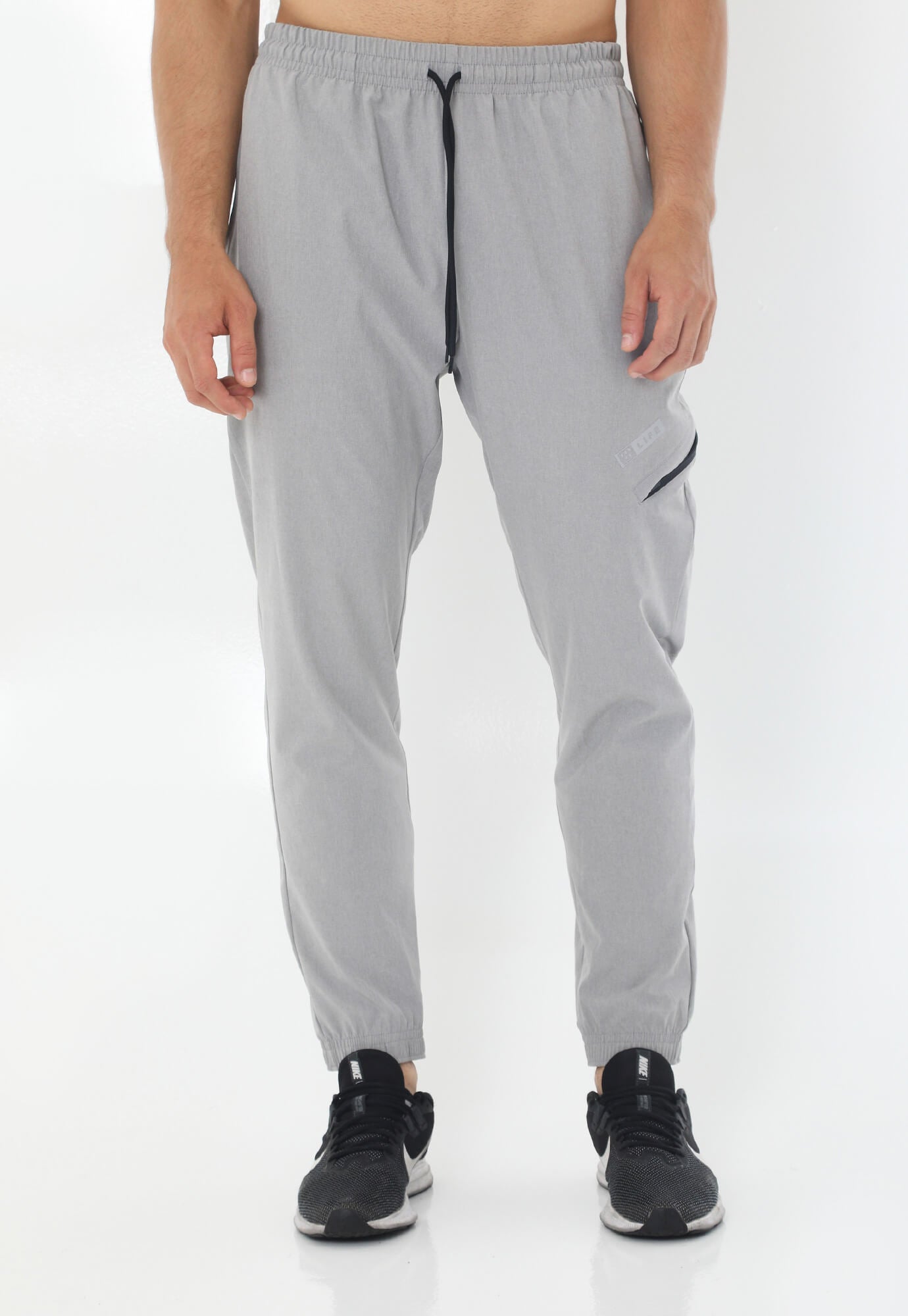 Pantalón deportivo gris tipo jogger con silueta ajustada con pretina y cordón ajustable para hombre