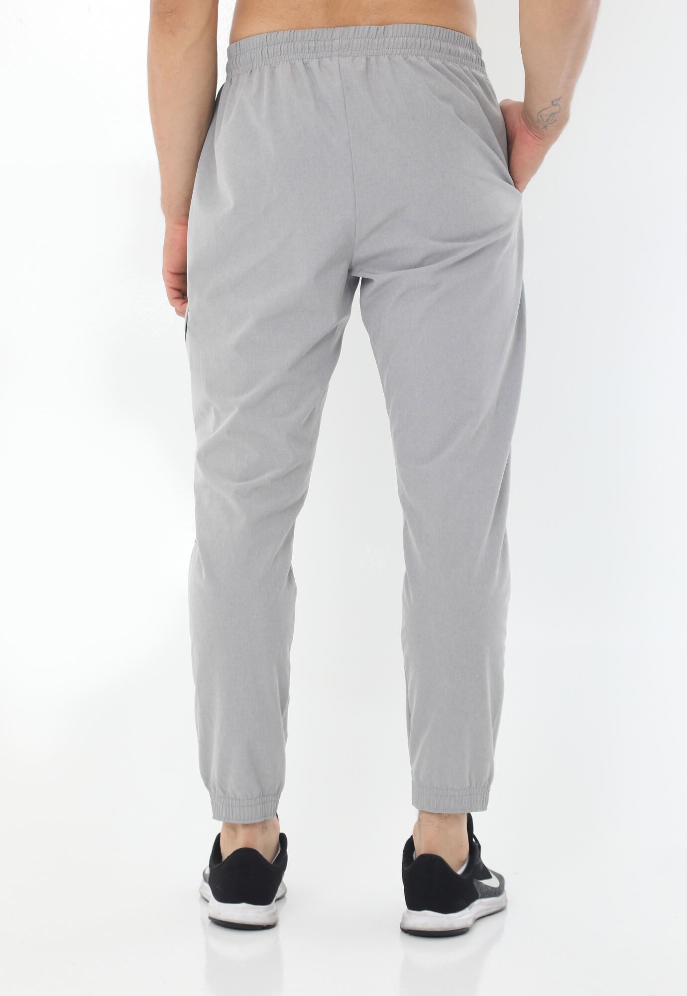 Pantalón deportivo gris tipo jogger con silueta ajustada con pretina y cordón ajustable para hombre